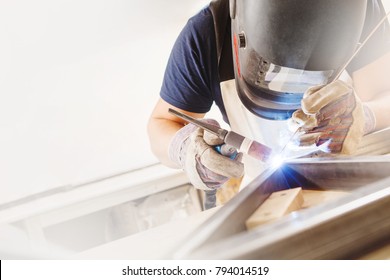 Male in face mask welds with argon-arc welding - Shutterstock ID 794014519