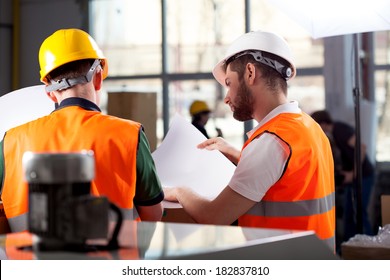 Male factory worker and supervisor are analyzing plans - Powered by Shutterstock