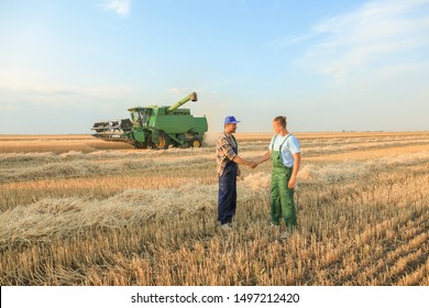 Male farmers shaking hands in wheat field