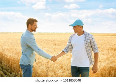 Male Farmers Shaking Hands In Wheat Field