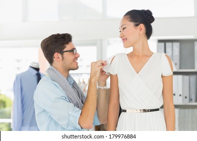 Male Fashion Designer Adjusting Dress On Model In The Studio