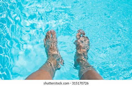 Male Feet Dipping In Swimming Pool