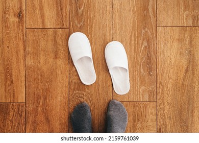 Male Feet And Disposable White Slippers In Hotel Room, Top View