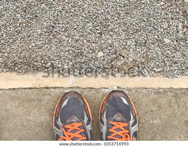 Male feet and old black shoes standing on the\
concrete floor or street asphalt pavement with dividing line. Space\
for text and design\
