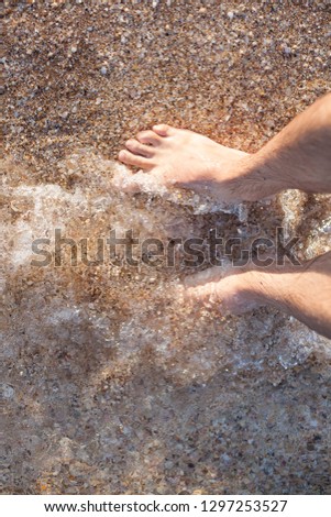 male feet on the sand. rest and sea air.