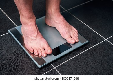 Male Feet On The Scale In The Bathroom
