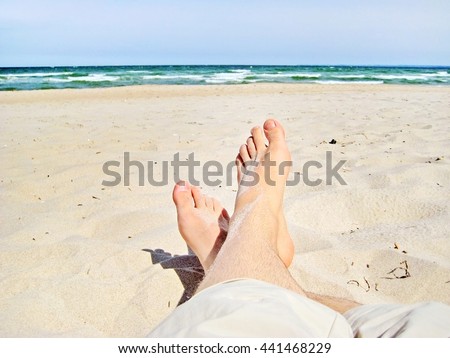 male feet at the sandy beach - legs with short trousers