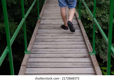 A Male Feet Walking On A Wooden Bridge In The Nature