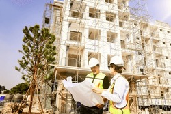 Male And Female Architects Caucasian Oversee Construction New Condominium Civil Engineers Inspect Blueprints Advise Planning Residential Projects Real Estate Luxury And Environmentally Friendly.