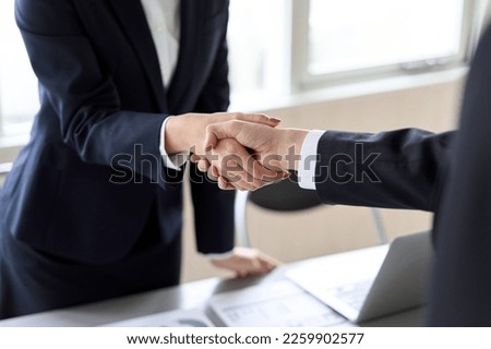 Male and female Asian business people shaking hands