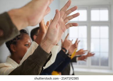 Male And Female Audience Raising Hands Up At Public Conference. Indoor Shot Of Diverse Mixed Race Multiethnic Crowd Of People Asking Questions At Seminar Session Or Masterclass. Close Up Of Human Hand