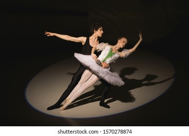 Male And Female Ballet Dancers Dancing On Stage In The Spotlight