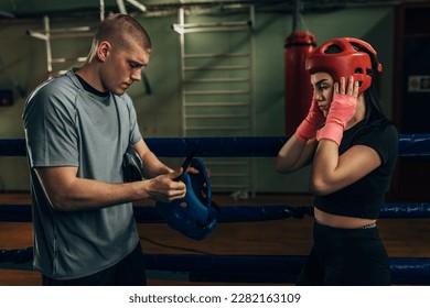 Male and female boxers put on a helmet - Powered by Shutterstock