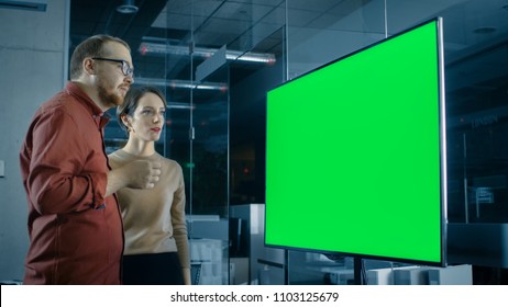 Male and Female Business Coworkers in Conference Room Have Discussion about Green Screen Chroma Key Template Shown on a Presentation TV. - Powered by Shutterstock