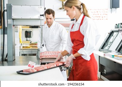 Male and female butchers processing meat in store - Powered by Shutterstock