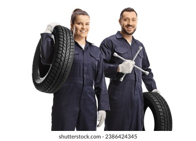 Male and female car mechanic workers holding lug wrench tool and a car tire isolated on white background - Powered by Shutterstock