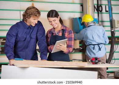 Male and female carpenters using digital tablet together in workshop - Powered by Shutterstock