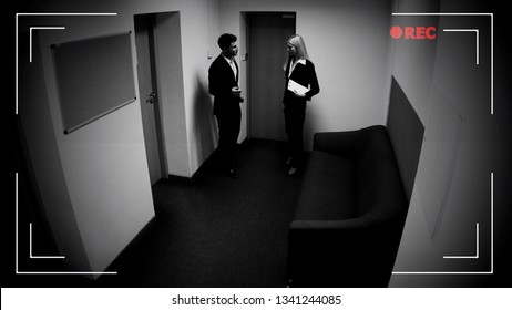 Male and female colleagues talking office corridor, CCTV camera effect, footage
