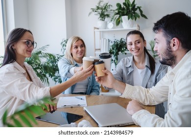 Male and female colleagues were smiling and clinking coffee cups at office. Successful team at the coffee break. Stock photo  - Powered by Shutterstock