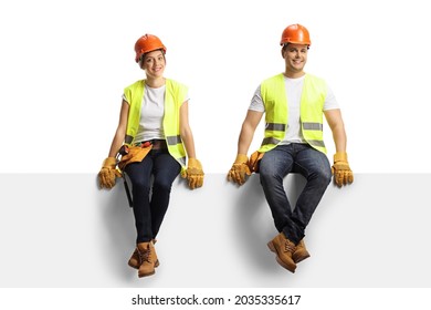 Male and female construction workers sitting on a panel and smiling at camera isolated on white background - Powered by Shutterstock