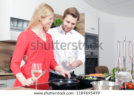 male and female Cook, couple, husband and wife cook in the kitchen and cut and slice salad and vegetables with a knife