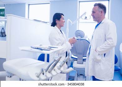 Male and female dentists discussing at dental clinic