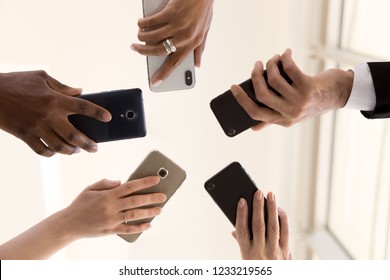 Male And Female Diverse Hands Holding Cell Phones, Multiracial Business People Using Smartphones Applications Software, Users And Devices Concept, Mobile Communication, Close Up Below Bottom View