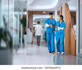 Male And Female Doctors Or Nurses In Scrubs With Digital Tablet In Hospital With Colleagues Behind