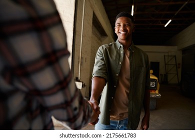 Male And Female Farmer Standing In Storeroom While Handshaking