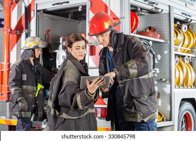 Male and female firefighters using tablet computer against truck at fire station - Powered by Shutterstock