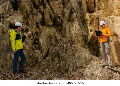 Male And Female Geologists Takes A Sample Of The Mineral And Record Data In A Canyon