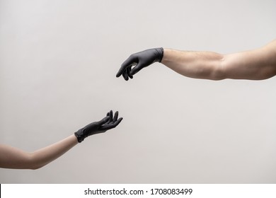 Male and female hand in black silicone gloves stretches to each other to touch. White background. COVID-19 virus protection concept. - Shutterstock ID 1708083499