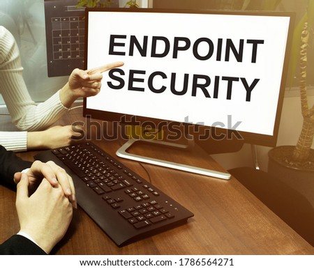 male and female hand, computer with text Endpoint Security with office background
