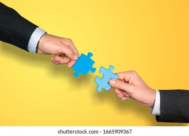 Male and female hand matching puzzle pieces together
