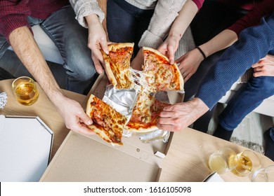 Male And Female Hands Grabbing Pieces Of Pizza. Movie Night At Home With Friends