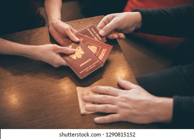 Male And Female Hands With Passports And Money On The Table - Concept Of Illegal Immigration, Sale Of Fake Passports, Sham (fake) Marriage 