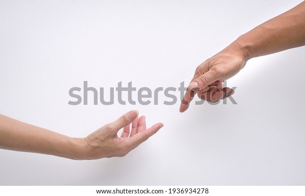 Male and female hands reaching out to each\
other, creation of adam sign. Isolated on white background. Concept\
of connection and human\
relations.