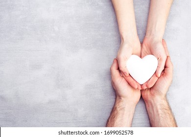 male and female hands with a white heart, health care, love and family insurance concept, world heart day, world health day, foster family, international family day