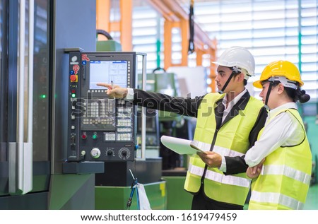 Male and Female Industrial Engineers in Hard Hats Discuss New Project or planning investment project working and strategy. business making conversation at Industrial injection molding factory concept