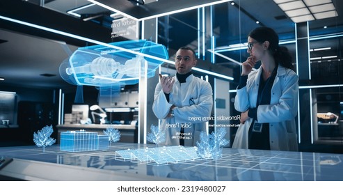 Male And Female Industrial Engineers Using Futuristic Technology Of Hologram of Wind Turbine Prototype In Computer Powered Laboratory. Multiethnic Colleagues Discussing a High-Tech VFX Projection. - Powered by Shutterstock