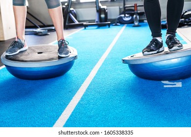 Male and female legs on bosu ball in fitness studio - Powered by Shutterstock