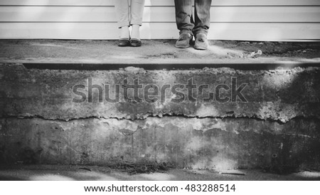 male and female legs standing on concrete
