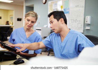 Male And Female Nurse Working At Nurses Station