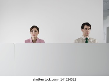 Male And Female Office Workers Behind The Cubicle Wall At Office