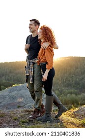 Male And Female On The Head Of Mountains In Nature, Travelling Together, Smiling, Feeling Happiness While Hiking, Casually Dressed, Caucasian Redhead Woman And Handsome Guy. Side View Portrait