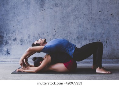 Male and female practicing yoga stretches together