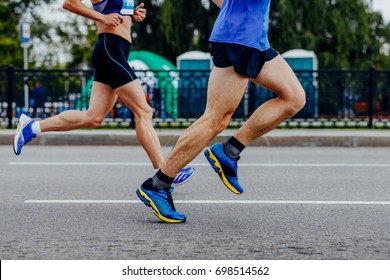 Male And Female Runners Running Urban Race Together