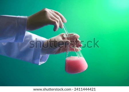 Male or female scientist with white gloves is stirring the chemical with a glass rod. Medicine experiment and chemical biology study in science laboratory research