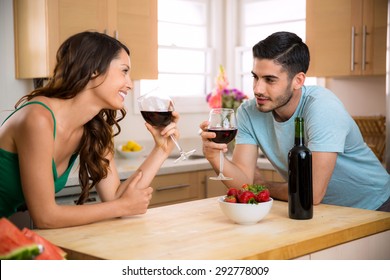 Male and female sipping red wine in the kitchen sharing a romantic gaze with chemistry - Powered by Shutterstock