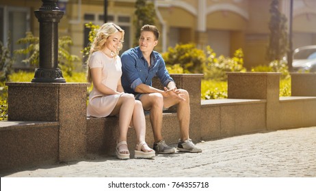 Male And Female Sitting On Bench Next To Each Other, Feeling Awkward, First Date